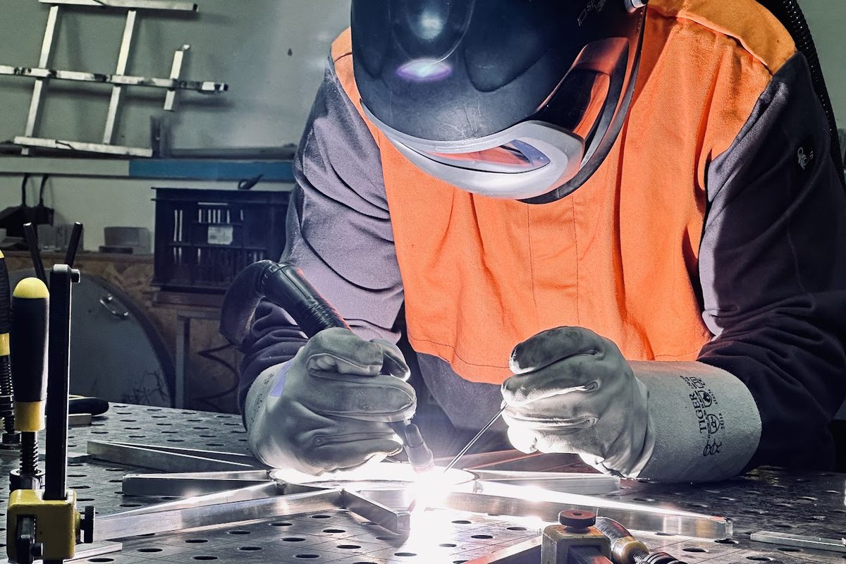 Lasser met beschermkap last de metalen constructie van een lichtster